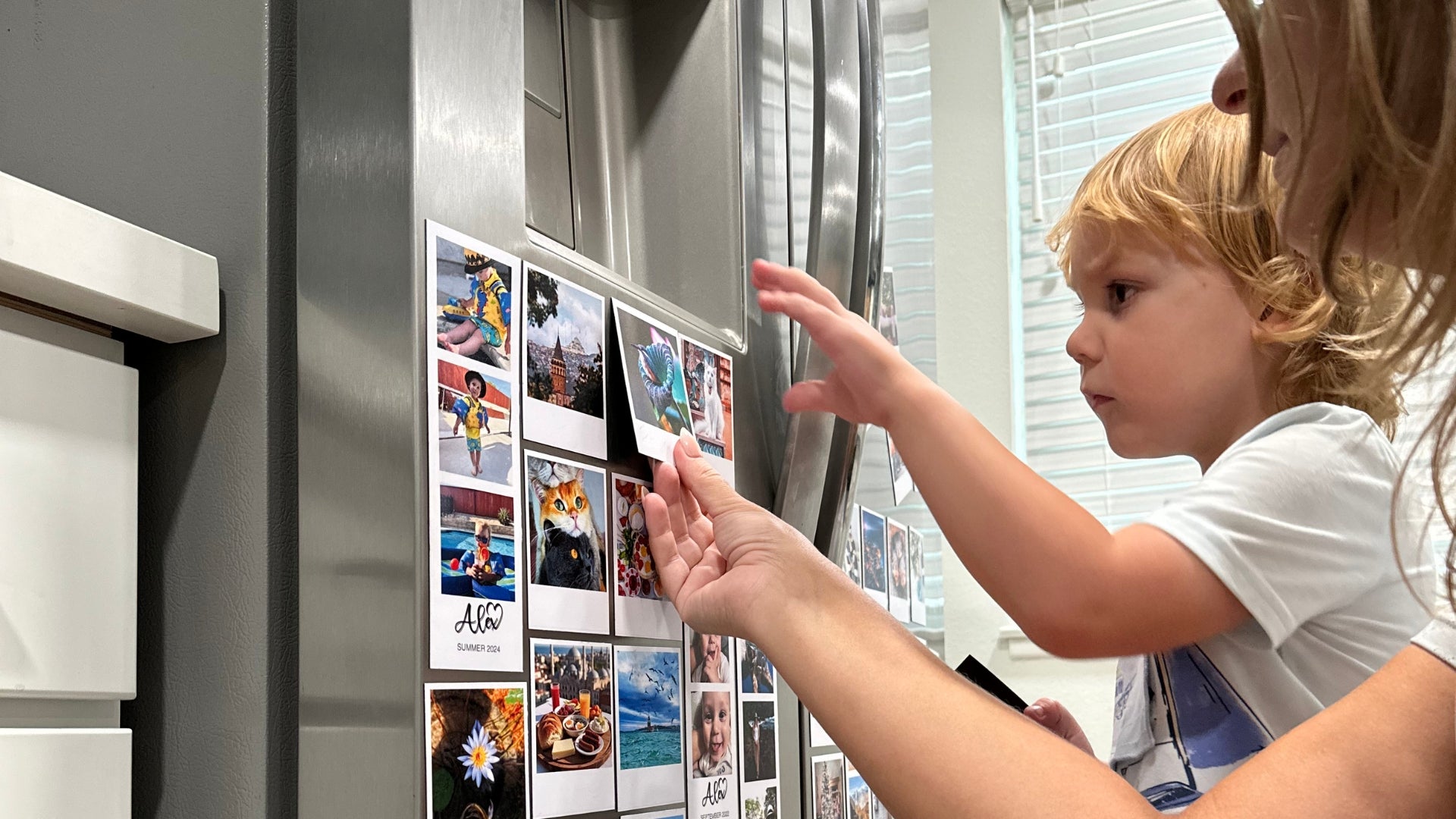 Woman and child looking at photo prints on a refrigerator door