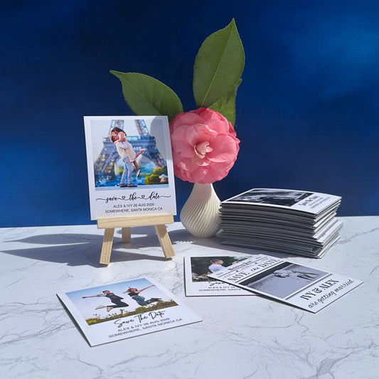 Set of save the date magnets with a pink flower and Eiffel Tower image on a blue background