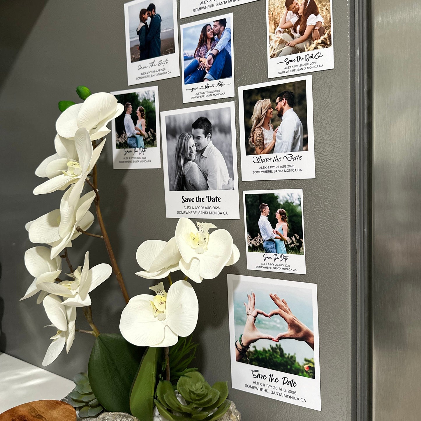 Fridge with custom made Save the Date photo magnets for various couples and white flowers on a gray surface