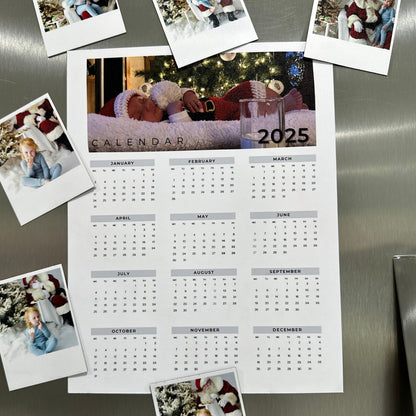Calendar for 2025 with photos attached to a stainless steel refrigerator.