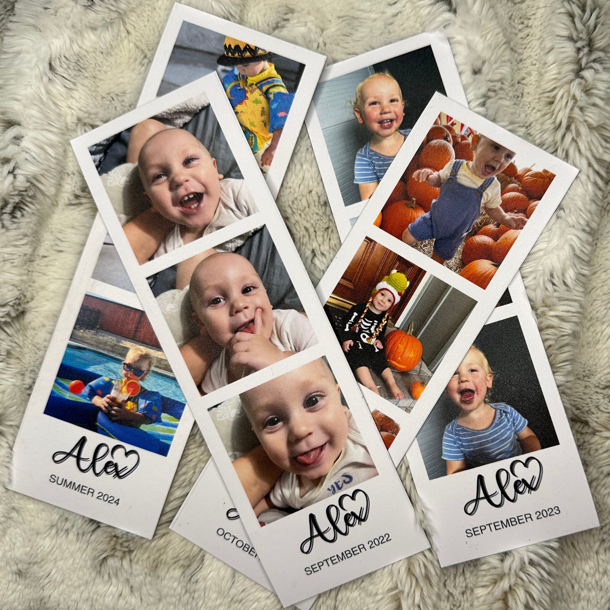Collection of custom phot booth strip magnets with baby photos and dates on a fluffy surface