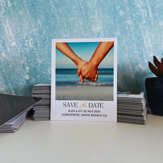 Save the date magnet with a photo of two hands holding each other against a blue ocean background.